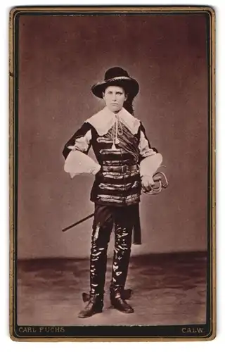 Fotografie Carl Fuchs, Calw, Portrait junger Knabe im Kostüm mit Degen und Hut, Lederstiefel