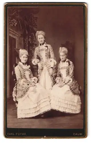 Fotografie Carl Fuchs, Calw, Portrait drei Damen in prachtvollen Kleidern posieren im Atelier
