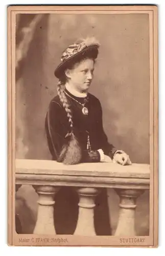 Fotografie C. Pfann, Stuttgart, Königsstr. 21, Portrait junge Frau im Samtkleid mit langem Zopf und Hut