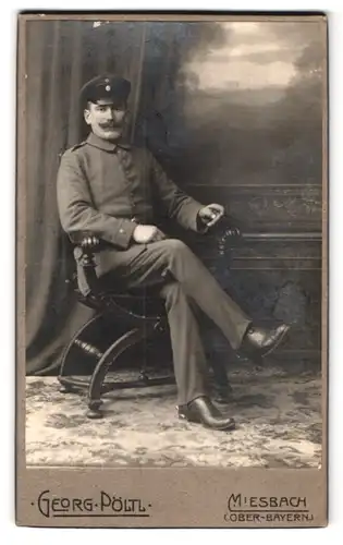 Fotografie Georg Pöltl, Miesbach, Rathausstr., Portrait bayrischer Soldat in Uniform vor einem Gemälde, Wilhelm II. Bart