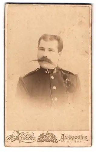 Fotografie Max Ketzler, Innsbruck, Portrait österreichischer Offizier in Uniform mit langem Schnauzbart, Schützenschnur