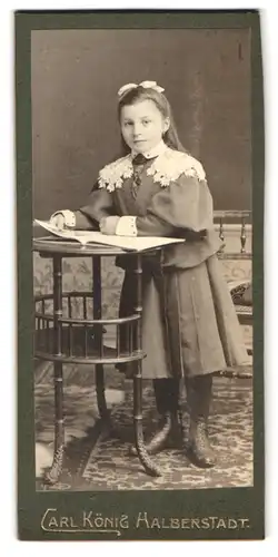 Fotografie Carl König, Halberstadt, Portrait hübsch gekleidetes Mädchen mit einem Buch