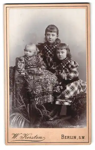 Fotografie W. Kersten, Berlin-SW, Krausen-Strasse 35, Portrait zwei kleine Mädchen in karierten Kleidern und Kleinkind