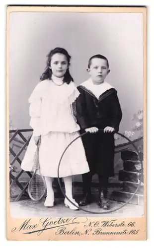 Fotografie Max Goetze, Berlin-N, Brunnenstrasse 165, Portrait hübsch gekleidetes Kinderpaar mit Reifen