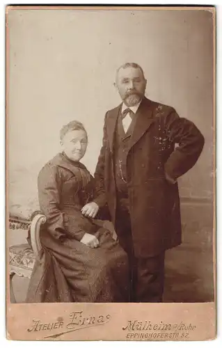 Fotografie Ateleir Erna, Mülheim a /Ruhr, Eppinghoferstrasse 52, Portrait älteres Paar in zeitgenössischer Kleidung