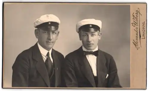 Fotografie Alexander Wiberg, Linköping, Portrait zwei Studenten in Anzügen mit Tellermütze