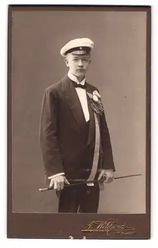 Fotografie A. Wiklund, Falun, Portrait junger Student im Anzug mit Flanierstock und Ansteckkranz