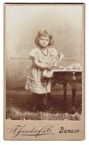 Fotografie A. Jandorf & Co., Berlin, Spittelmarkt 16 /17, Portrait kleines Mädchen im Kleid mit Puppe in der Hand
