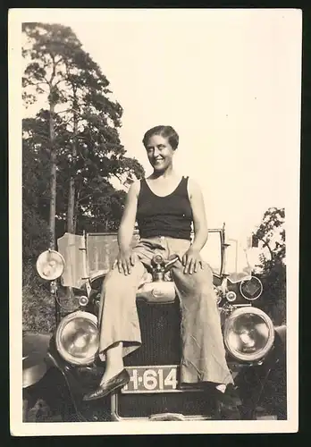 Fotografie Auto Cabrio, Brünette Dame auf Motorhaube sitzend