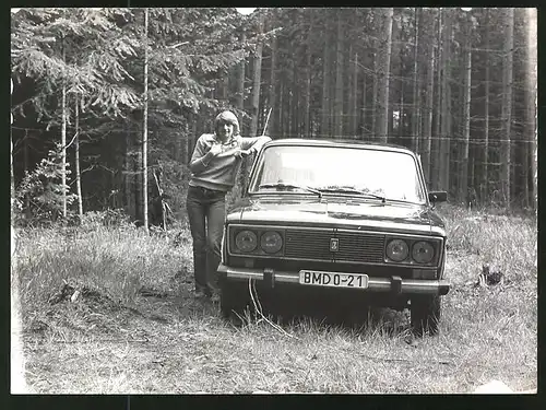 Fotografie Auto Lada, Bursche lehnt lässig am PKW