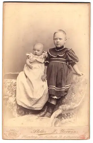 Fotografie D. Wettern, Hamburg, Gr. Theaterstrasse 22, Portrait kleines Mädchen im Kleid mit einem Baby