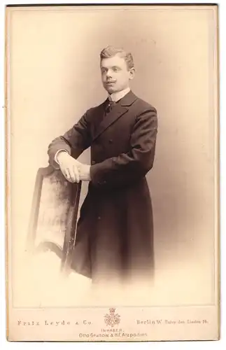 Fotografie Fritz Leyde & Co., Berlin-W., Unter den Linden 16, Portrait junger Herr im Mantel mit Krawatte