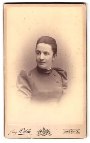 Fotografie August Wilcke, Innsbruck, Rudolfstr. 3, Portrait dunkelhaarige Schönheit mit Brosche am Kleiderkragen