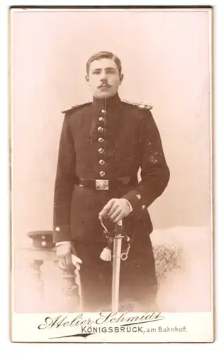 Fotografie Atelier Schmidt, Königsbrück, Soldat in Uniform mit Säbel und Epauletten