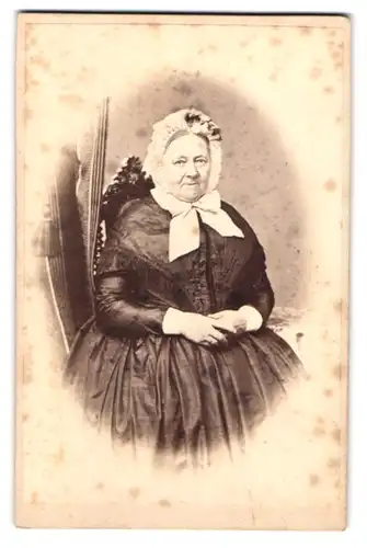 Fotografie Wilh. Riberholdt, Aarhus, Vestergade 614, Portrait älterer Dame im seidenen Kleid mit Schleife und Haube