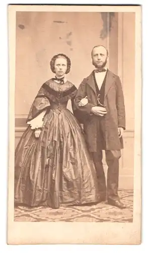 Fotografie unbekannter Fotograf und Ort, Portrait Paar im reifrock Kleid und Anzug mit Backenbart