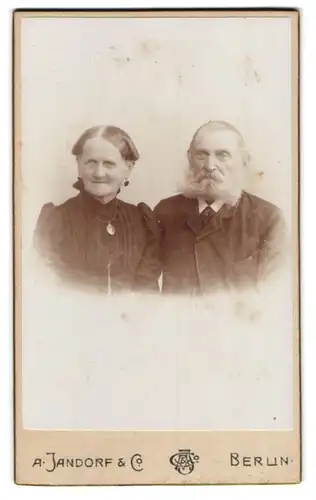 Fotografie A. Jandorf & Co., Berlin-C., Spittelmarkt 16-17, Portrait älteres Paar in hübscher Kleidung