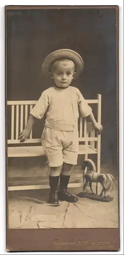 Fotografie Samson & Co., Bremen, Hutfilterstrasse 9-13, Portrait modisch gekleideter Junge mit Spielpferd