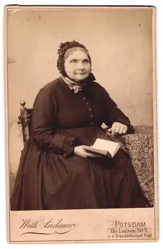 Fotografie Wilh. Andauer, Potsdam, Alte Louisen-Strasse 6, Portrait ältere Dame im Kleid mit Haube und Buch