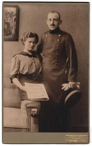 Fotografie W. Reinhardt, Husum, Katharinenstrasse 10, Portrait Soldat in Uniform und Frau mit Zeitung