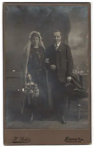 Fotografie G. Gober, Simbach a /Inn, Dultstrasse 2, Portrait junges Paar in Hochzeitskleidung mit Schleier & Blumenkorb