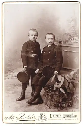 Fotografie Ad. Richter, Leipzig-Lindenau, Merseburgerstrasse 61, Portrait zwei Jungen im Anzug mit Schirmmütze