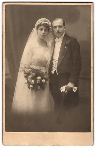 Fotografie unbekannter Fotograf und Ort, Portrait Eheleute um Hochzeitskleid mit Schleier und Anzug mit Zylinder