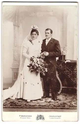 Fotografie F. Bergmann, Ingolstadt, Theresienstr. 329, Portrait Eheleute im Hochzeitskleid und Anzug mit Zylinder