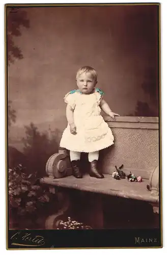 Fotografie Hertel, Mainz, grosse Bleiche 50, Portrait niedliches Mädchen im weissen Kleidchen auf der Bank