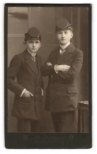 Fotografie M. Lüttgens, Görlitz, Steinstr. 14, Portrait zwei junge Studenten Knaben in Anzügen mit Stürmer Mützen