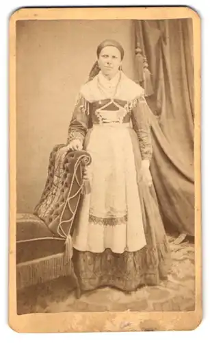 Fotografie X. Peuthauser, Wasserburg, Marienplatz, Portrait Dame im Trachtenkleid stützt sich auf einen Sessel