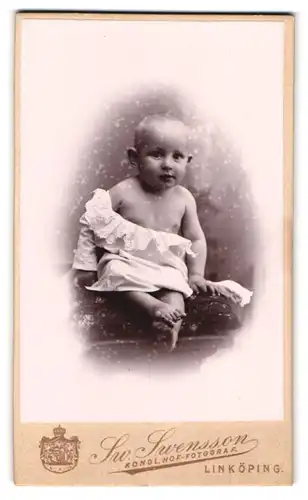 Fotografie Sw. Swensson, Linköping, Wadstena, Portrait niedliches Baby im weissen Hemdchen mit Stickerei