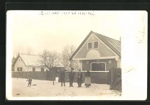 Foto-AK Mcely, Familie steht vor ihrem Haus, Winteridylle
