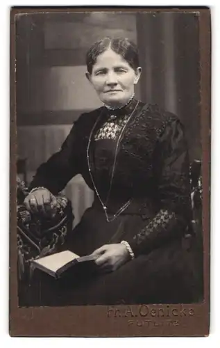 Fotografie Fr. A. Oenicke, Putlitz, Portrait ältere Dame im Kleid mit Buch