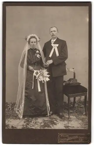 Fotografie Cresz. Herlinger, Triftern /Bayern, Portrait bürgerliches Paar in Hochzeitskleidung mit Schleier und Blumen