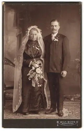Fotografie Wilh. Boos, Pfarrkirchen, Portrait bürgerliches Paar in Hochzeitskleidung mit Schleier und Blumenstrauss