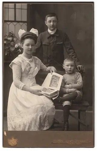 Fotografie Hans Weis, Memmingen, Portrait junge Dame im Kleid mit Zeitung und zwei Jungen
