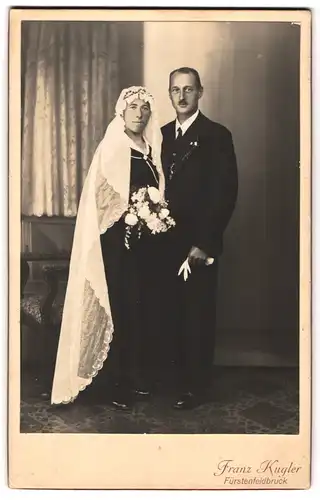 Fotografie Franz Kugler, Fürstenfeldbruck, Portrait junges Paar in Hochzeitskleidung mit Schleier und Blumenstrauss