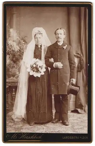 Fotografie M. Hirschbeck, Landsberg a /Lech, Portrait junges Paar in Hochzeitskleidung mit Schleier und Blumenstrauss