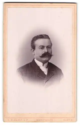 Fotografie E. Biegner & Comp., Guben, Am Wilhelmsplatz 9, Portrait modisch gekleideter Herr mit Moustache