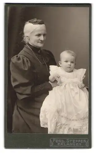 Fotografie Ferd. Steffen, Erlangen, Oestl. Stadtmauerstrasse 14, Portrait ältere Dame im Kleid mit einem Kleinkind