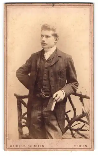 Fotografie Wilhelm Kersten, Berlin-SW, Krausen-Strasse 40, Portrait junger Herr im Anzug mit Buch in der Hand