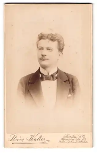 Fotografie Strom & Walter, Berlin-SO, Köpenicker-Strasse 102, Portrait junger Herr im Anzug mit Fliege