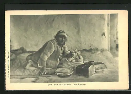 AK Balkan Typen, alte Bettlerin auf einer Decke sitzend