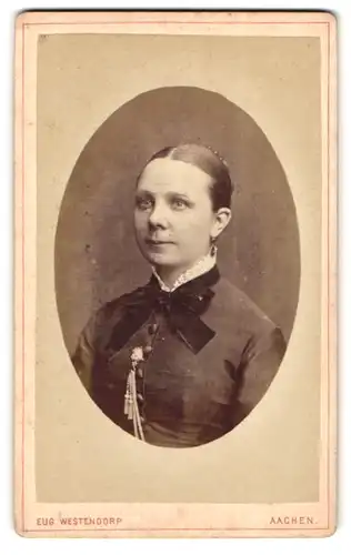 Fotografie Eug. Westendorp, Aachen, Damengraben 19, Brustportrait junge Dame mit Ohrringen und Kragenschleife