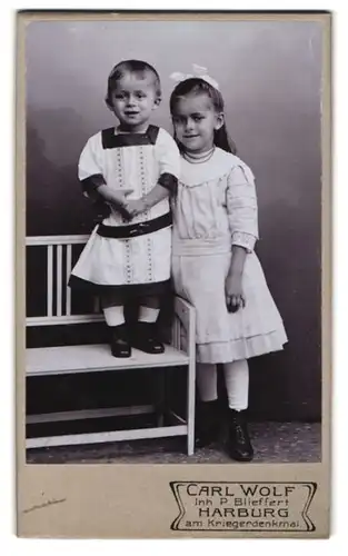 Fotografie Carl Wolf, Harburg, Portrait Mädchen im Kleid mit Schwesterchen im Arm