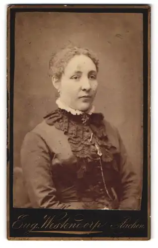 Fotografie Eug. Westendorp, Aachen, Hochstr. 8, Portrait Dame im Biedermeierkleid mit Locken und Brosche