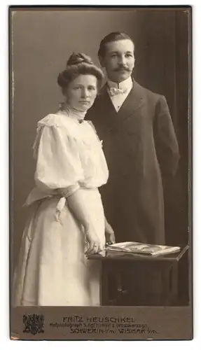 Fotografie Fritz Heuschkel, Schwerin i. M., Wismarsche Str. 34, Portrait Mann und Frau im Kleid und Anzug mit Moustache