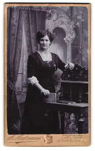 Fotografie H. Hartmann, Berlin, Gr. Frankfurterstr. 75, Portrait Dame im Biedermeierkleid lehnt am Sekretär