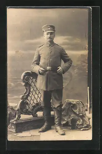 Foto-AK Soldat mit Schirmmütze in Feldgrau, Uniformfoto